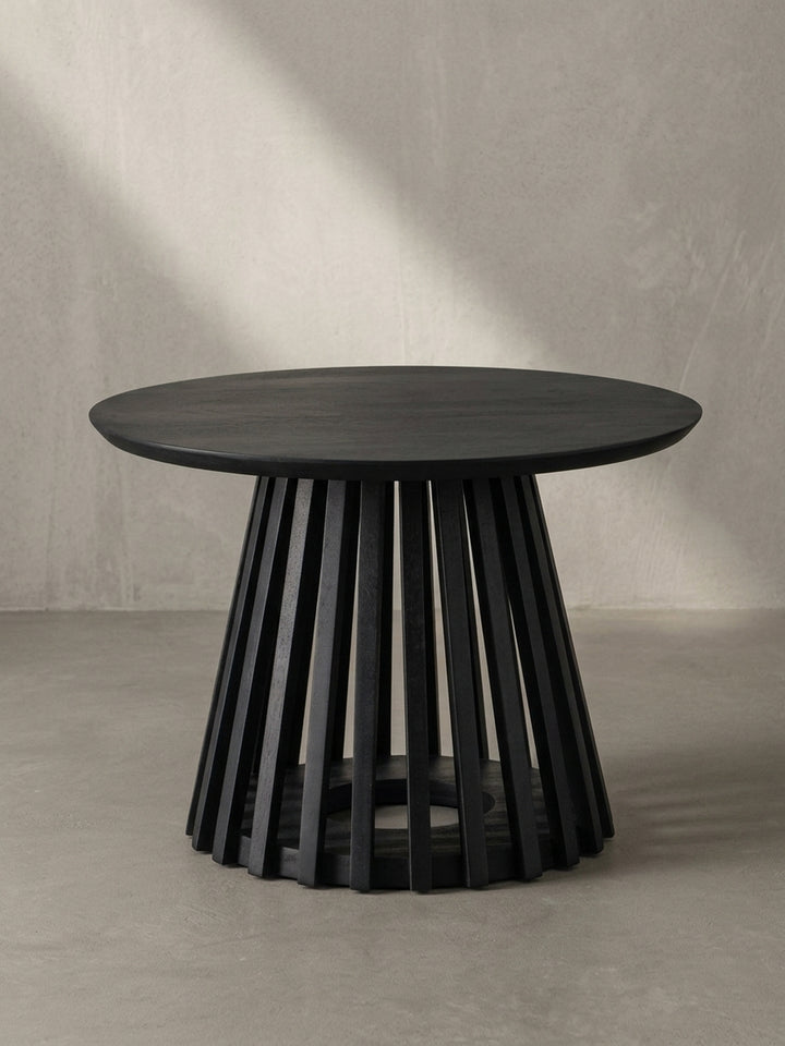 Nahaufnahme des Gittergestells, das die saubere Verarbeitung der einzelnen Holzlatten des schwarz lackierten Couchtisches demonstriert._