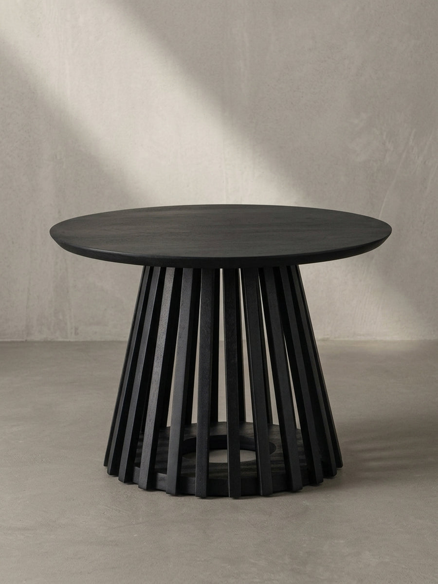 Nahaufnahme des Gittergestells, das die saubere Verarbeitung der einzelnen Holzlatten des schwarz lackierten Couchtisches demonstriert._