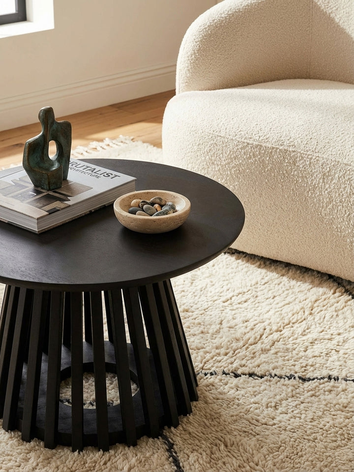 Moderner Wohnzimmertisch in Schwarz, dekoriert mit einem Chanel-Bildband und einer abstrakten Skulptur, für ein stilvolles Ambiente._