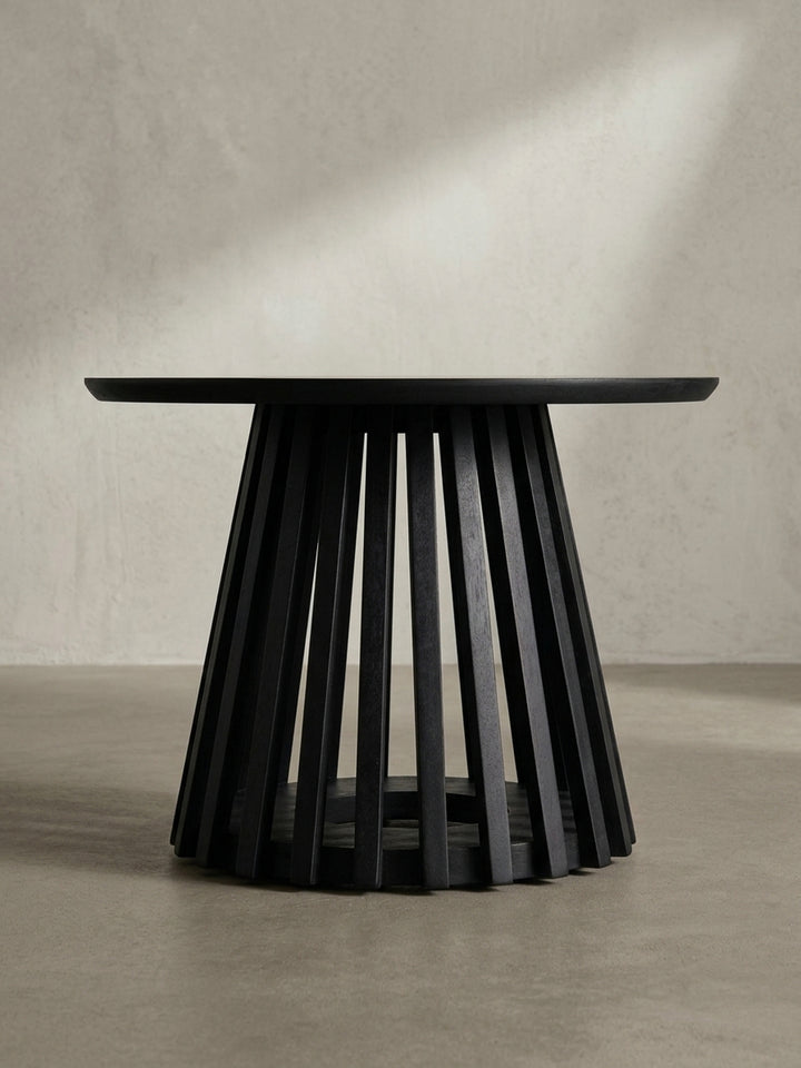 Design-Sofatisch aus massivem Mangoholz in der Dreiviertelansicht, die die Tiefe des offenen Gittergestells und die runde Form hervorhebt._