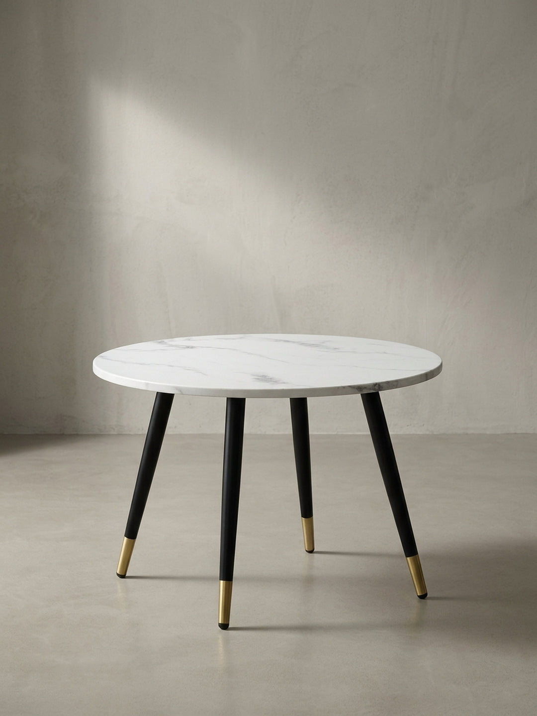Freigestellter Couchtisch in runder Form mit 60 cm Durchmesser, weißer MDF-Tischplatte und konischen schwarzen Metallbeinen_