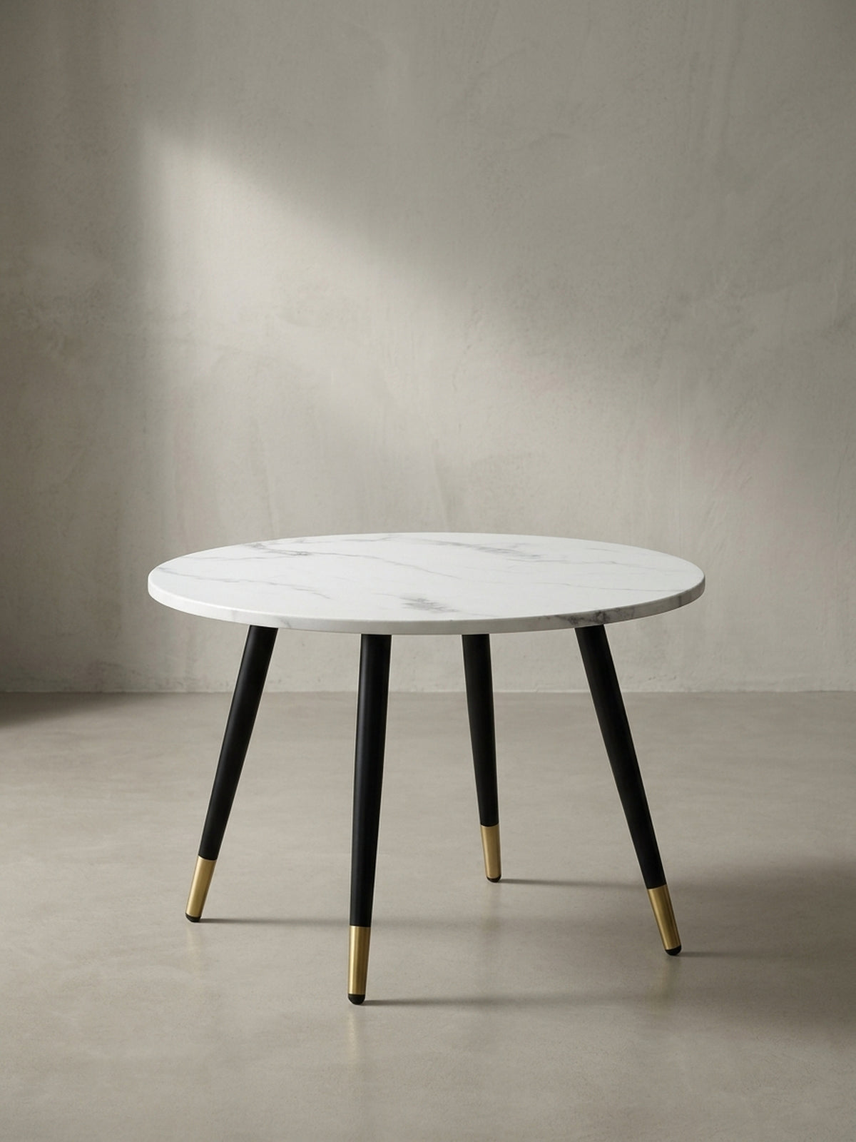 Freigestellter Couchtisch in runder Form mit 60 cm Durchmesser, weißer MDF-Tischplatte und konischen schwarzen Metallbeinen