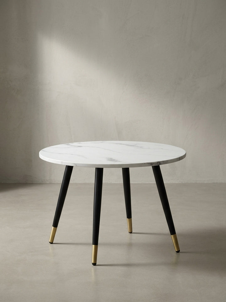 Freigestellter Couchtisch in runder Form mit 60 cm Durchmesser, weißer MDF-Tischplatte und konischen schwarzen Metallbeinen_