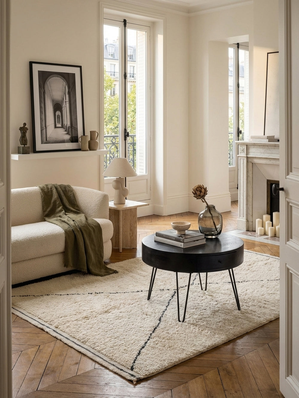 Eleganter runder Couchtisch aus massivem Mangoholz in Schwarz, zentral platziert in einem lichtdurchfluteten Wohnzimmer auf einem cremefarbenen Berberteppich._