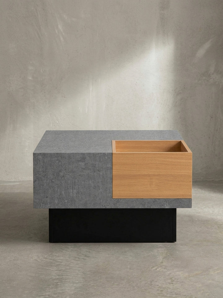 Detailansicht der präzisen Tischkante des 65x65x40 cm Sofatisches, die den glatten Übergang zwischen dem grauen Block und dem holzfarbenen Ablagebereich zeigt._