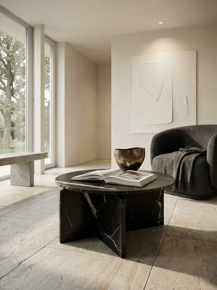 Moderner Loungetisch mit architektonischem Kreuzgestell in Kombination mit einem hellen Stoffsofa vor einer glatt verputzten weißen Wand_