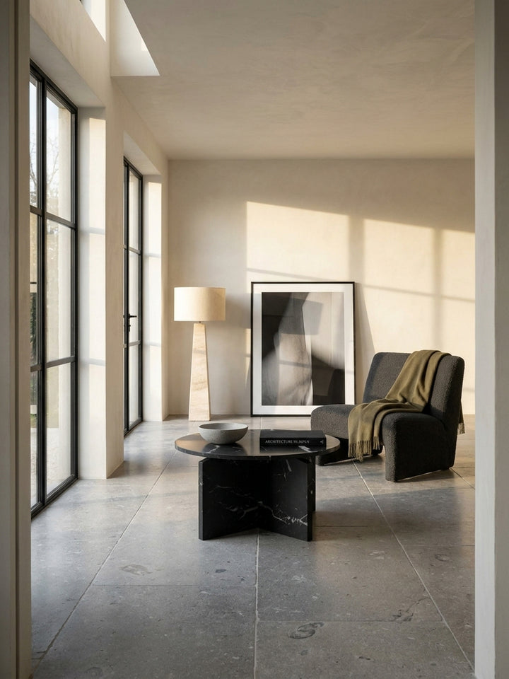 Moderner Couchtisch in schwarzer Marmor-Optik mit Kreuzgestell 60x60 cm im minimalistischen Wohnzimmer auf handgeschliffenem Kalksteinboden_