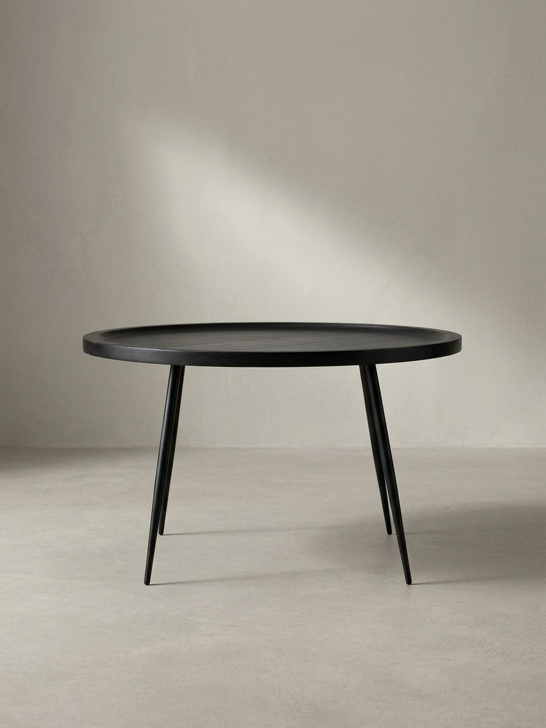 Seitenprofil des schwarzen Wohnzimmertisches mit einer Höhe von 38 cm, der die Proportionen der schlanken Metallbeine und der Tablett-Tischplatte zeigt._