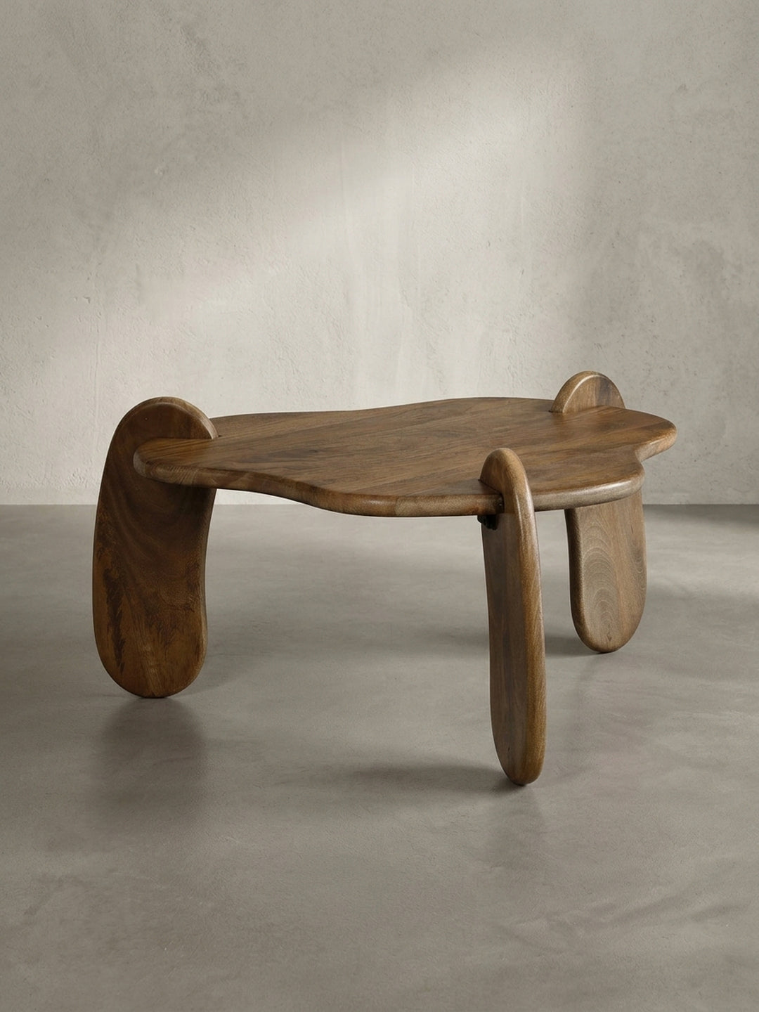 Seitenprofil des niedrigen Couchtisches aus Massivholz, das seine elegante, bodennahe Statur und die geschwungene Form der Beine hervorhebt._