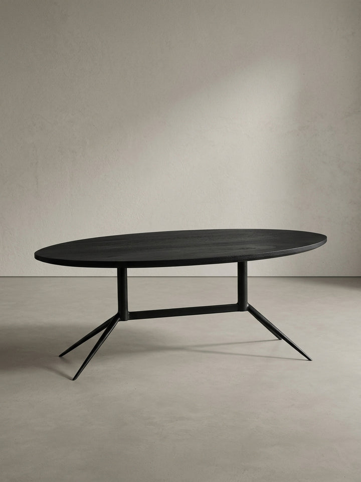 Sofatisch 90x50 cm in Schwarz von schräg vorne mit Fokus auf die elegante ovale Form und die abgewinkelten schmalen Metallbeine_
