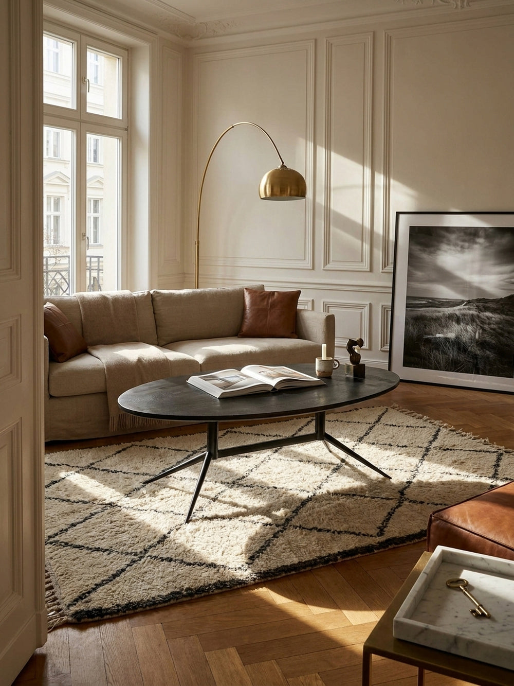 Eleganter Couchtisch oval aus massivem schwarzem Mangoholz vor hellem Leinensofa auf einem strukturierten cremefarbenen Wollteppich in einem modernen Wohnzimmer_