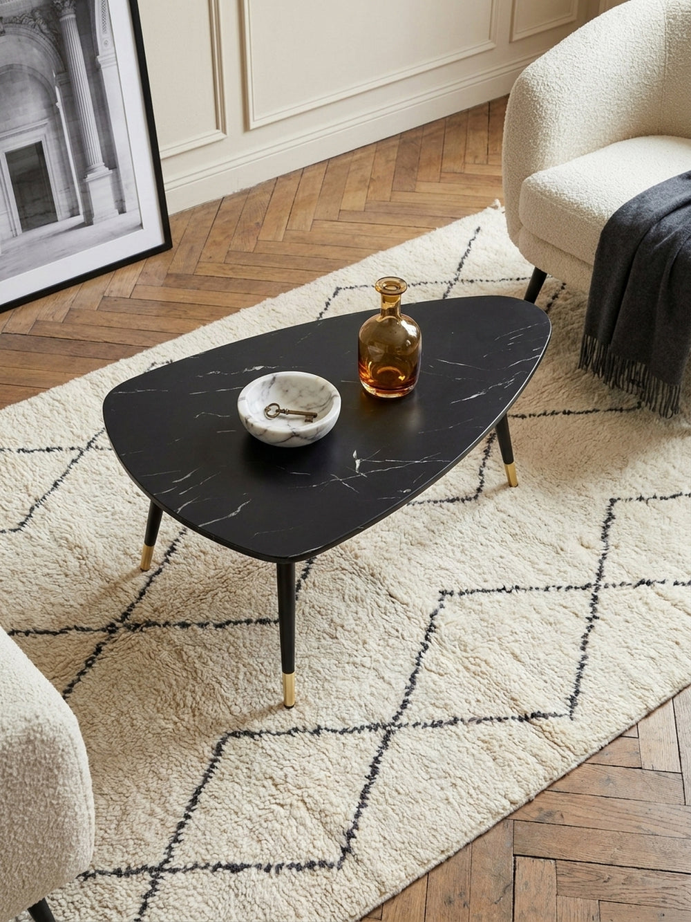 Draufsicht auf den dreieckigen Couchtisch aus foliertem MDF, platziert zwischen einem eleganten Leinensofa und einem Travertin-Beistelltisch._