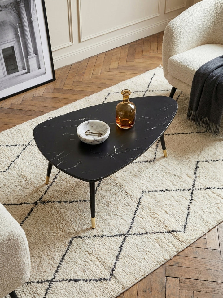 Draufsicht auf den dreieckigen Couchtisch aus foliertem MDF, platziert zwischen einem eleganten Leinensofa und einem Travertin-Beistelltisch._