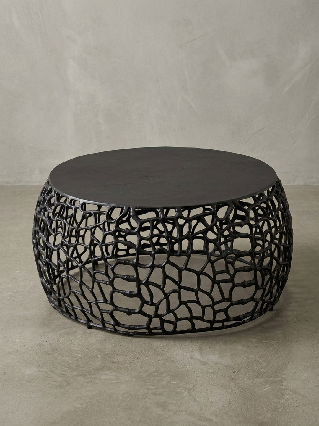 Runder Couchtisch aus schwarzem Metall vor weißem Hintergrund, der Sofatisch überzeugt mit seiner filigranen Ast-Struktur und einer soliden Tischplatte._