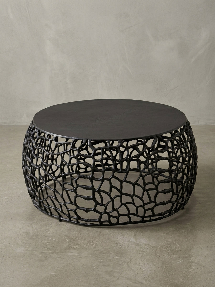 Runder Couchtisch aus schwarzem Metall vor weißem Hintergrund, der Sofatisch überzeugt mit seiner filigranen Ast-Struktur und einer soliden Tischplatte._