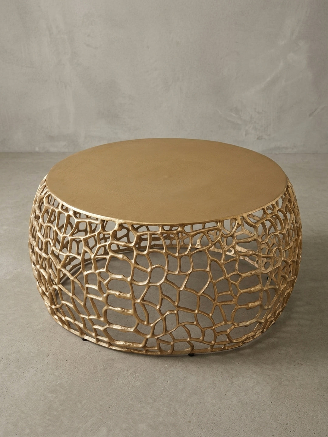 Makroaufnahme des Randes der 55 cm Tischplatte des goldenen Couchtischs, die den Übergang von der glatten Oberfläche zur organischen Basisstruktur betont._