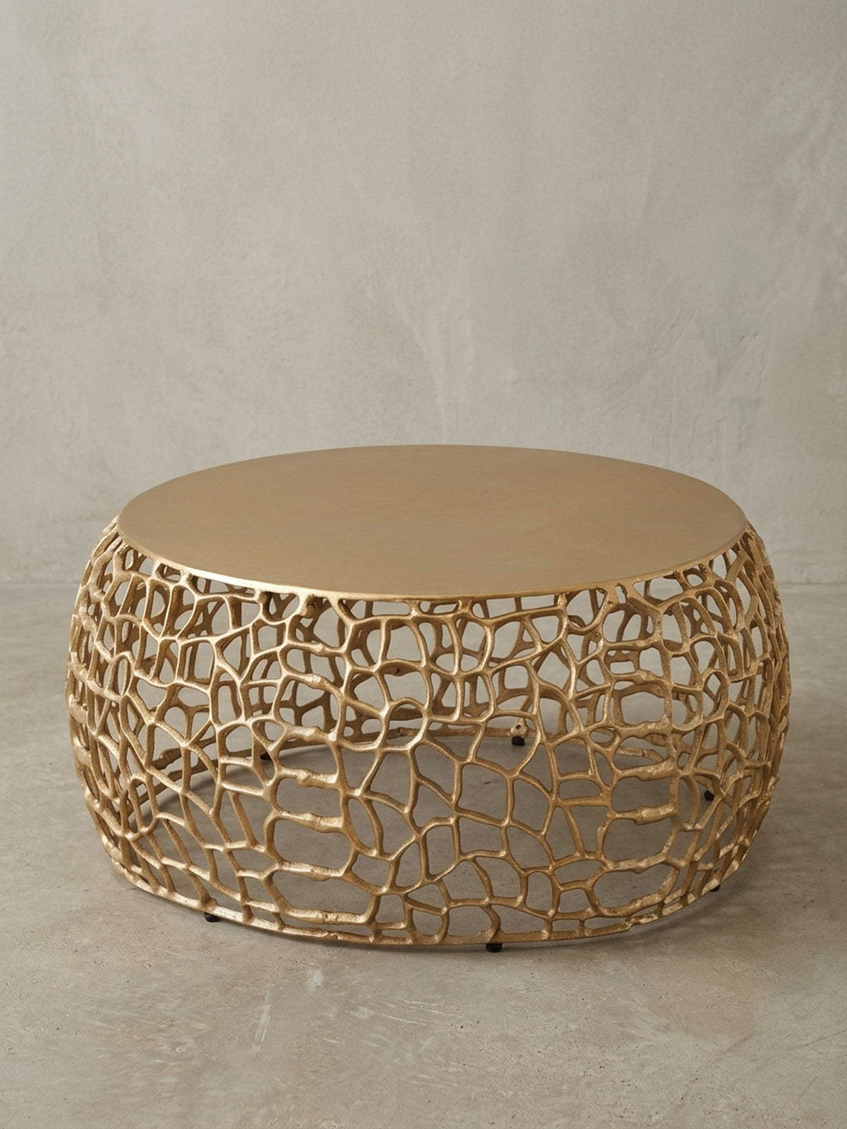 Seitenansicht des 30 cm hohen Kaffeetischs in Gold, die seine niedrige, breite Silhouette und die Proportionen von massiver Platte zu luftiger Basis hervorhebt.