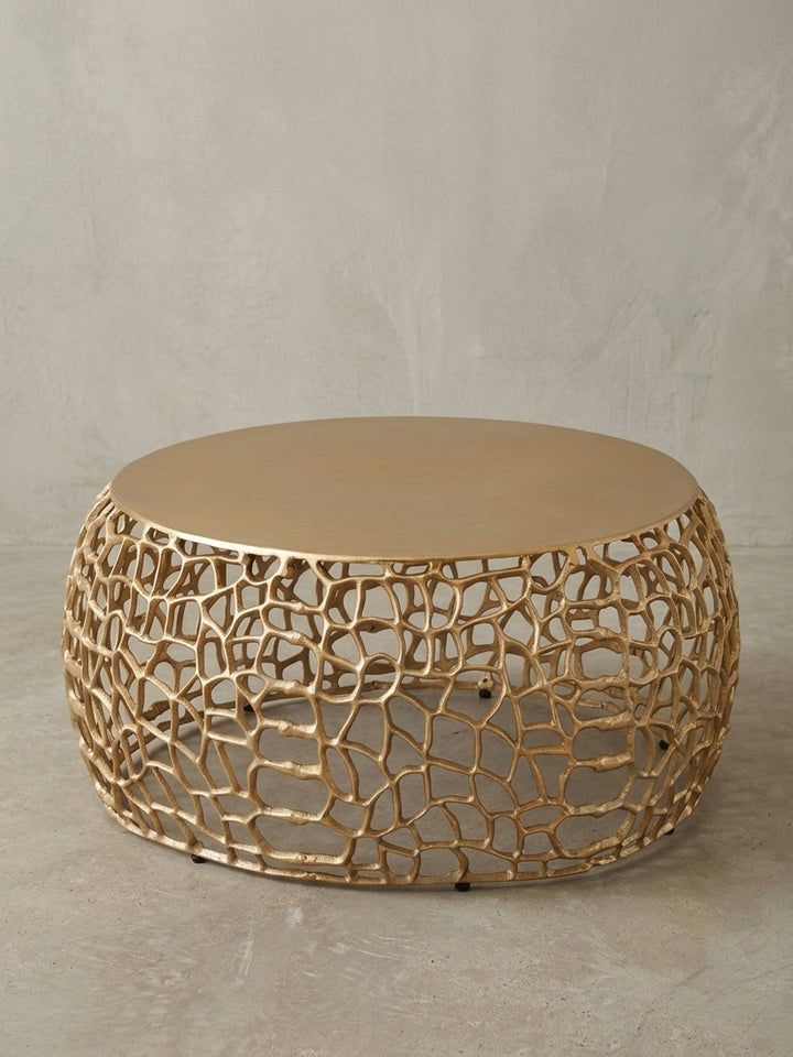 Seitenansicht des 30 cm hohen Kaffeetischs in Gold, die seine niedrige, breite Silhouette und die Proportionen von massiver Platte zu luftiger Basis hervorhebt._