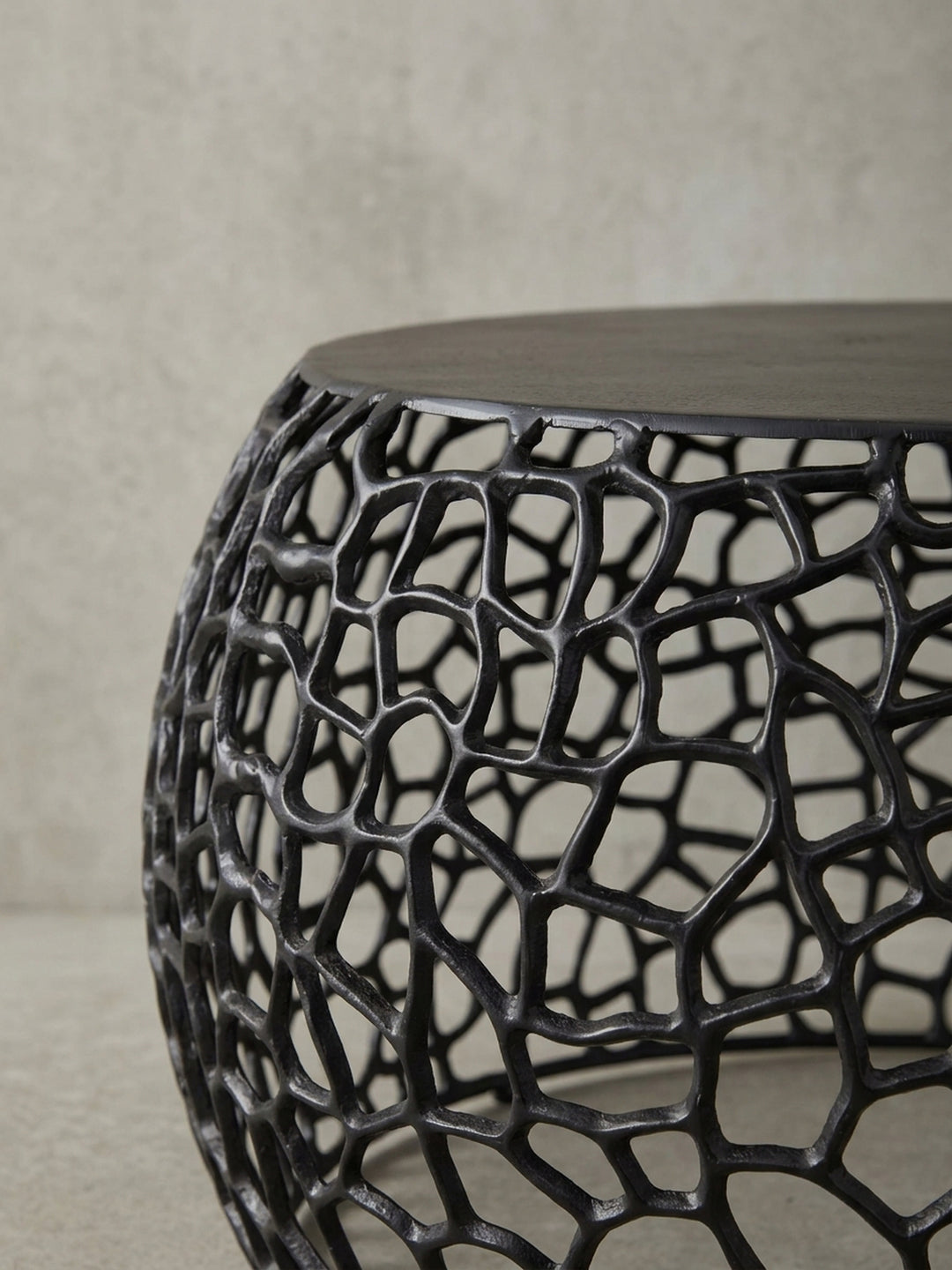 Nahaufnahme des filigranen Geflechts des Couchtischs, die organisch geformten Aluminium-Äste bilden eine stabile und dekorative Basis für den Tisch._