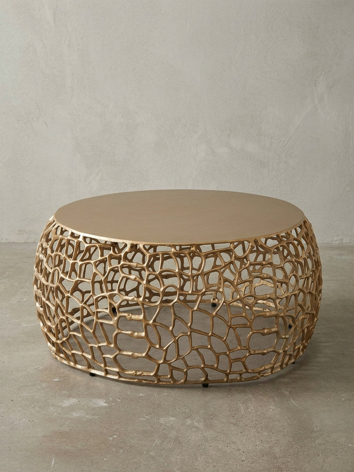 Frontansicht des runden Couchtischs in Gold, 66 cm breit, auf weißem Hintergrund, der die organische, astähnliche Basis und die massive Tischplatte klar darstellt._