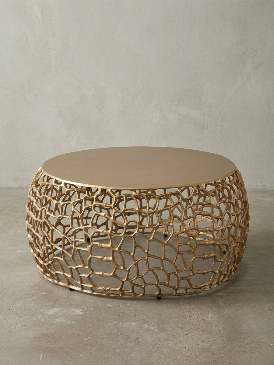 Frontansicht des runden Couchtischs in Gold, 66 cm breit, auf weißem Hintergrund, der die organische, astähnliche Basis und die massive Tischplatte klar darstellt._