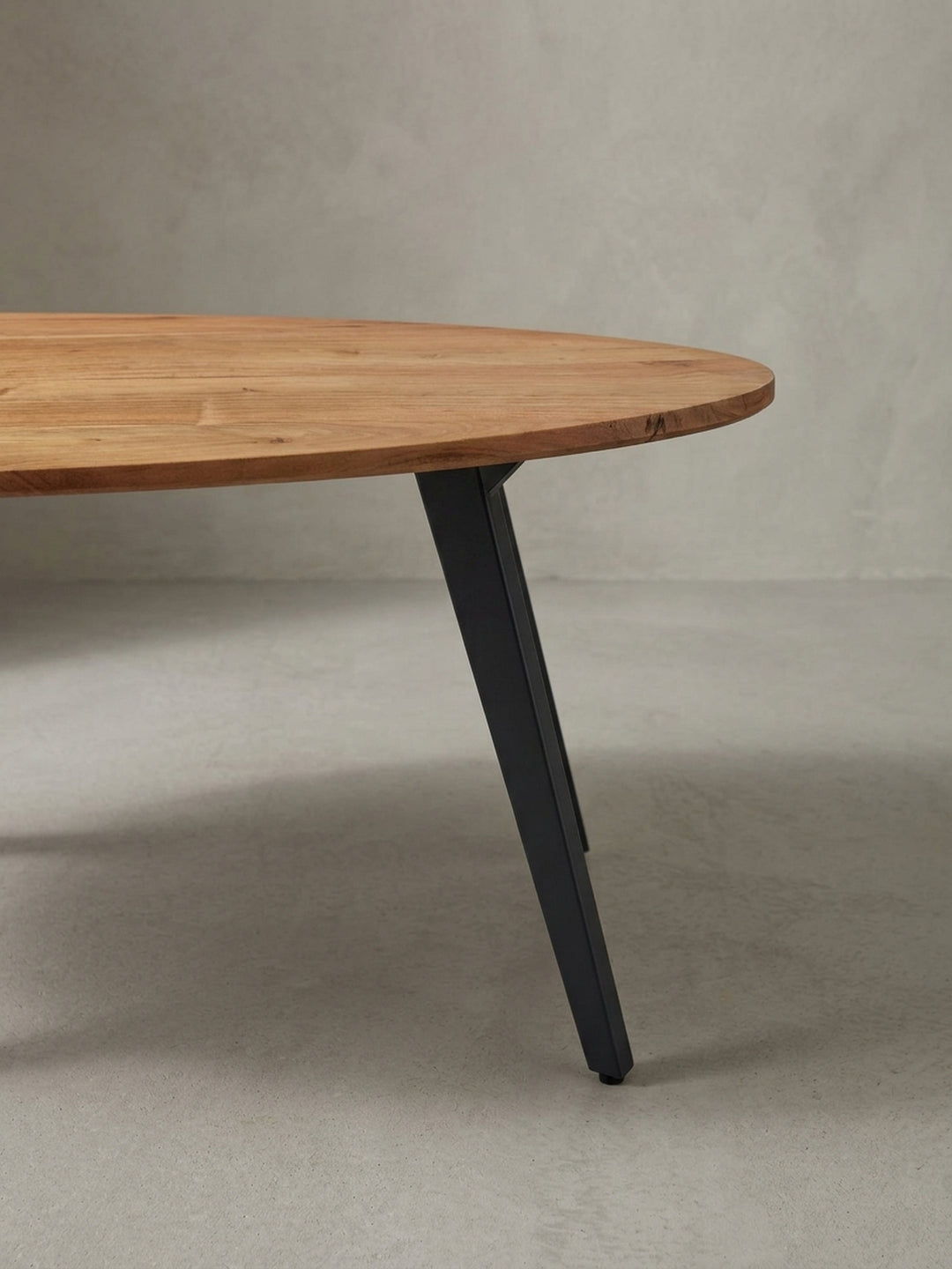 Alternative Perspektive des Couchtisches, die den eleganten Schwung der nierenförmigen Kontur und das Zusammenspiel von warmem Holz und kühlem Metall hervorhebt._