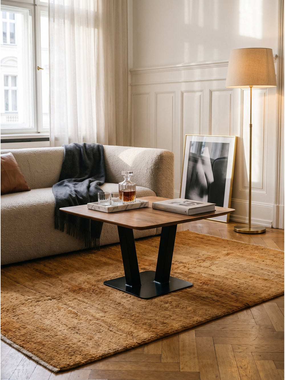 Massivholz Couchtisch mit schwarzem Eisengestell harmonisch kombiniert mit einem sandfarbenen Sessel und dunkelgrauem Kaschmir-Plaid._