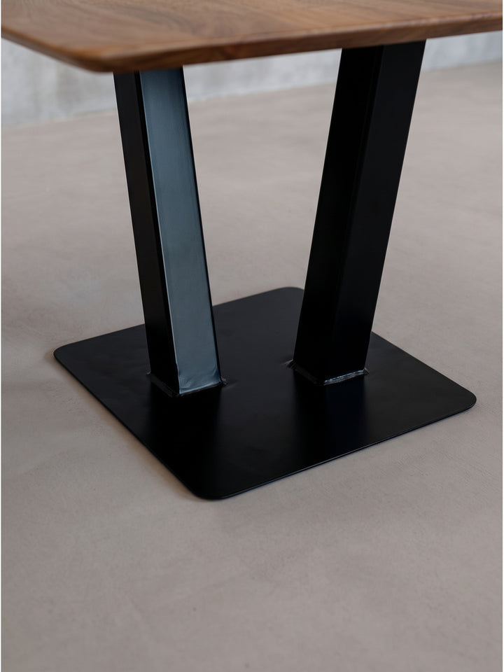 Kompakter Couchtisch aus Akazienholz und dunklem Eisen präsentiert im hellen Studio seine natürliche Holzoberfläche mit mattem Schutzlack._