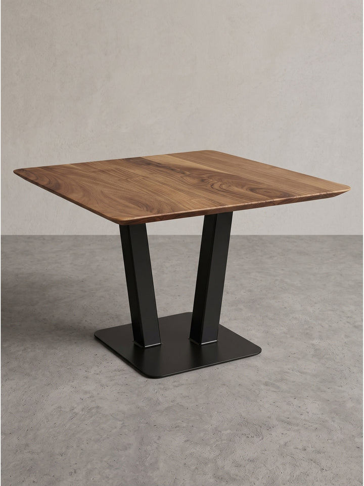 Freigestellter Couchtisch mit den exakten Maßen 60x60x40 cm zeigt das kontrastreiche Design aus warmer Akazie und schwarzem Eisen._