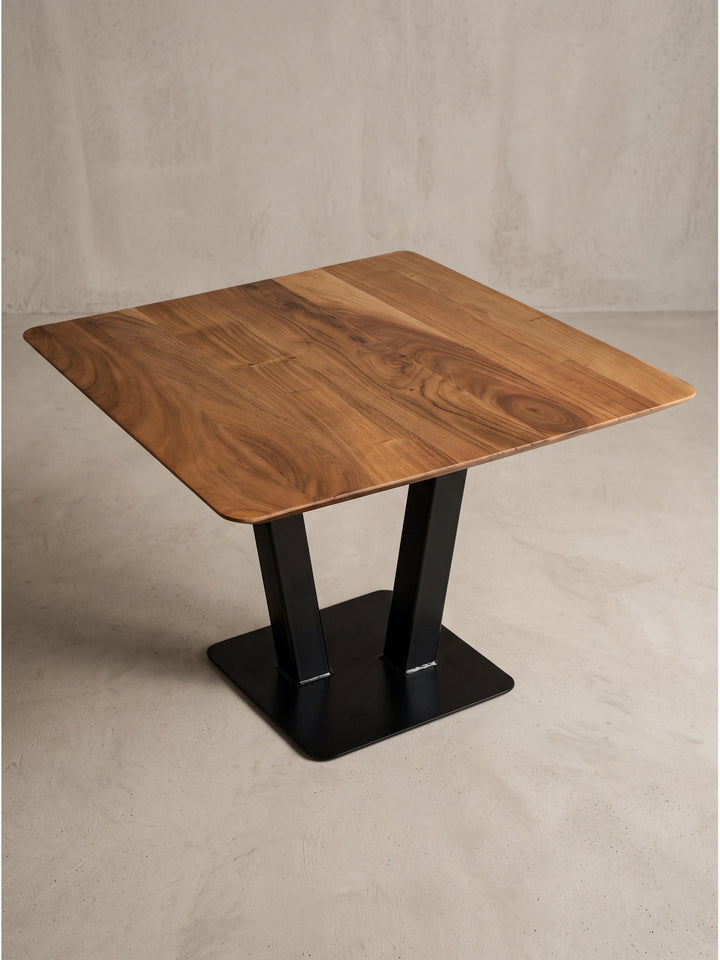Design Couchtisch im Industrial Stil präsentiert seine quadratische massive Tischplatte und die markanten V-förmigen Metallbeine._