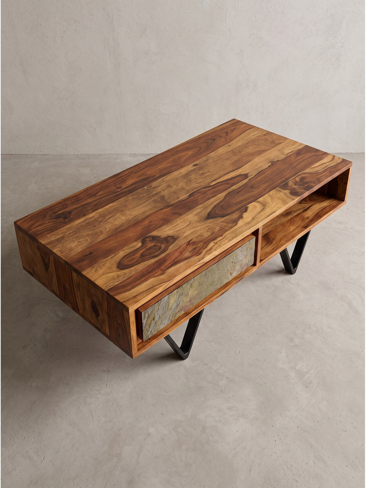 Geräumiger Couchtisch aus massivem Sheeshamholz mit offenem Ablagefach und geschlossener Schublade in moderner Steinoptik in Schrägansicht_