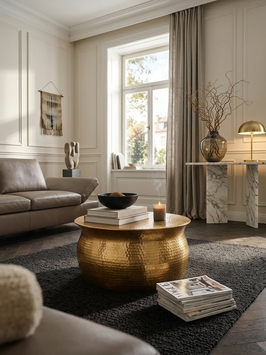 Luxuriöser runder Couchtisch aus Aluminium in Gold mit Hammerschlag-Muster im eleganten Wohnzimmer. Der niedrige 60x30cm Metalltisch bildet ein Highlight auf dem dunklen Bouclé-Teppich._