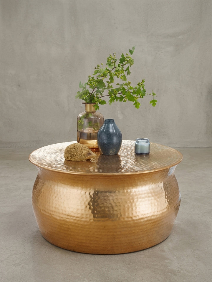 Runder Couchtisch Gold in bauchiger Form freigestellt. Der 60x60x30 cm kleine Wohnzimmertisch aus Aluminium besticht durch sein modernes orientalisches Design und den breiten Rand._