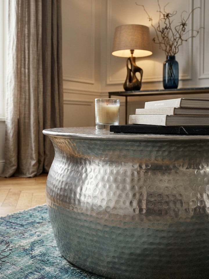 Nahaufnahme der handgefertigten Hammerschlag-Struktur des orientalischen Beistelltisches. Das glänzende silberne Aluminium zeigt eine detailreiche, wellige Oberflächenbeschaffenheit._
