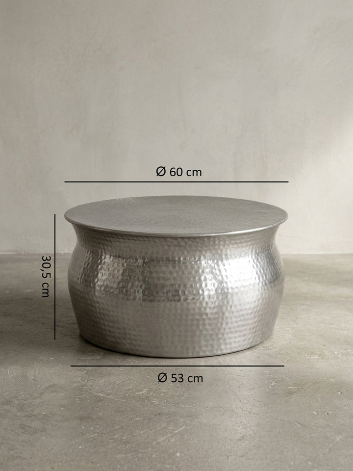 Detailansicht der unteren Konstruktion des runden Metall-Couchtisches. Der silberne Aluminiumkorpus steht stabil auf dem Boden und fügt sich nahtlos in elegante Wohnzimmer ein._