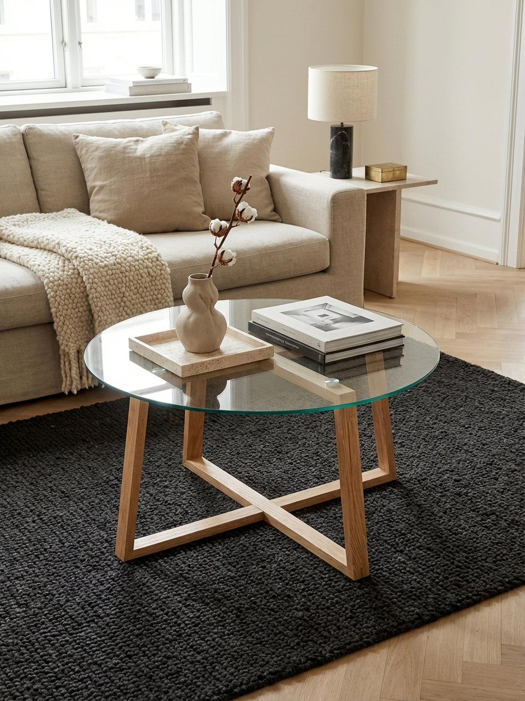 Design Couchtisch aus Eiche massiv von oben fotografiert, zeigt die runde Glasplatte mit 78 cm Durchmesser und die harmonische Anordnung im Wohnzimmer._