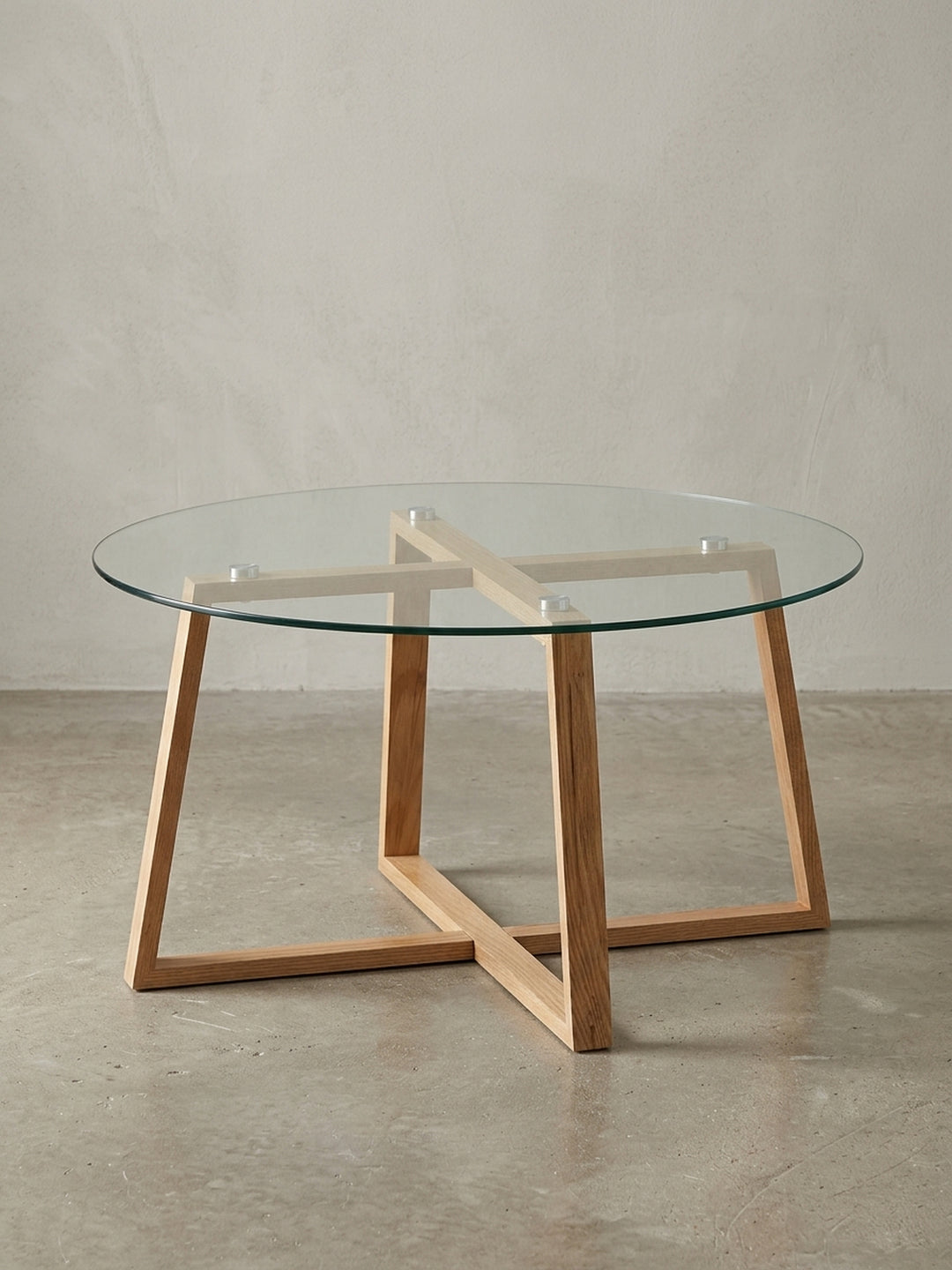 Moderner runder Couchtisch mit einem Gestell aus massivem Eichenholz und einer Glasplatte, freigestellt vor weißem Hintergrund in Frontalansicht._