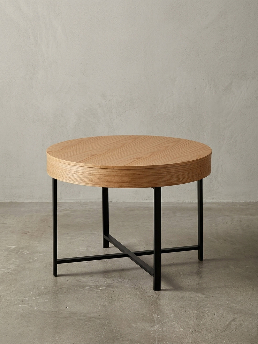 Freigestellter Design Couchtisch mit Eichenfurnier und schwarzem Metallgestell, runde Form, frontale Ansicht auf weißem Hintergrund._