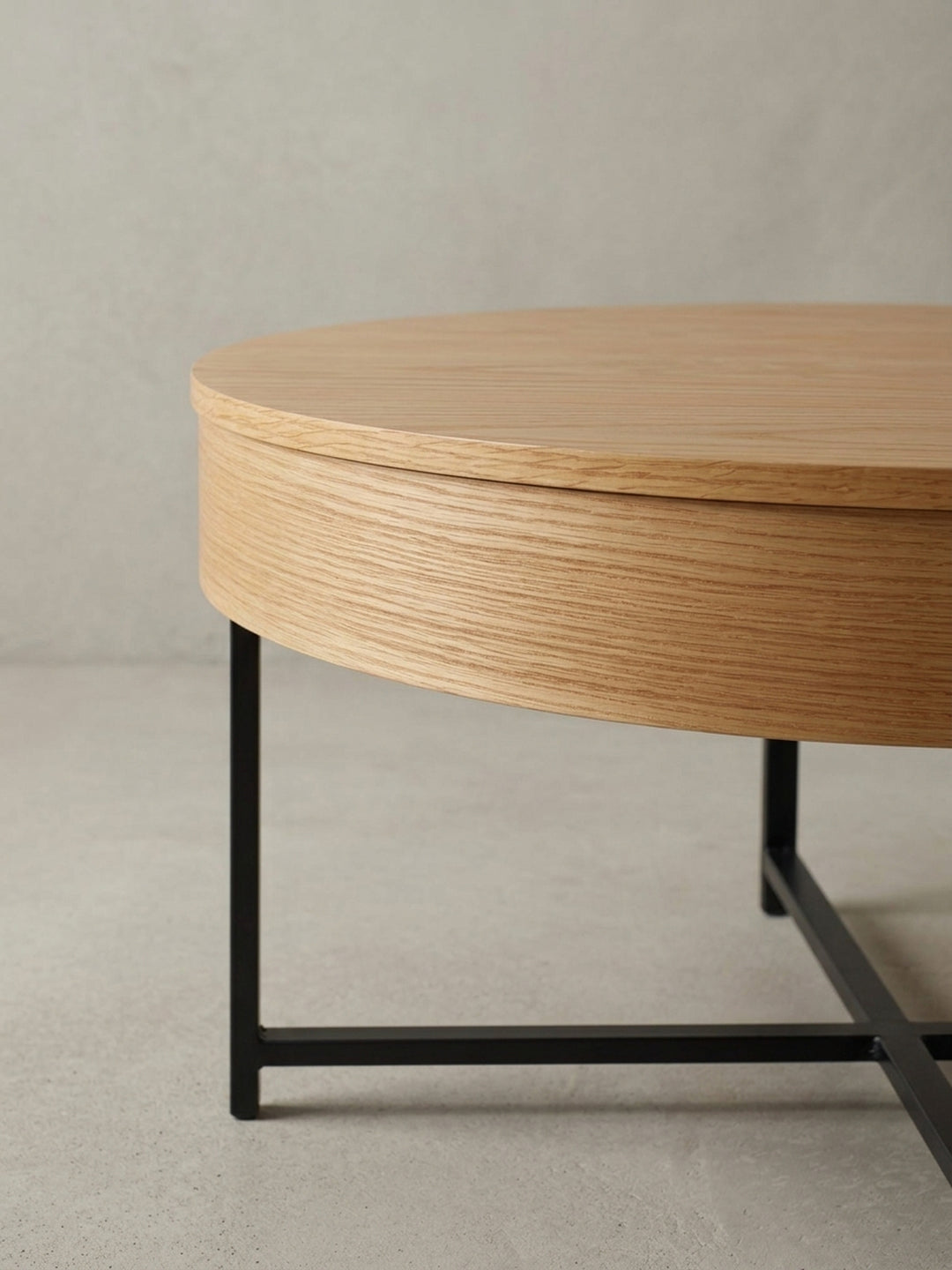 Detailaufnahme des Übergangs von der Eichenfurnier-Tischplatte zum mattschwarzen Stahlbein, die den Materialmix des modernen Lounge-Tisches betont._