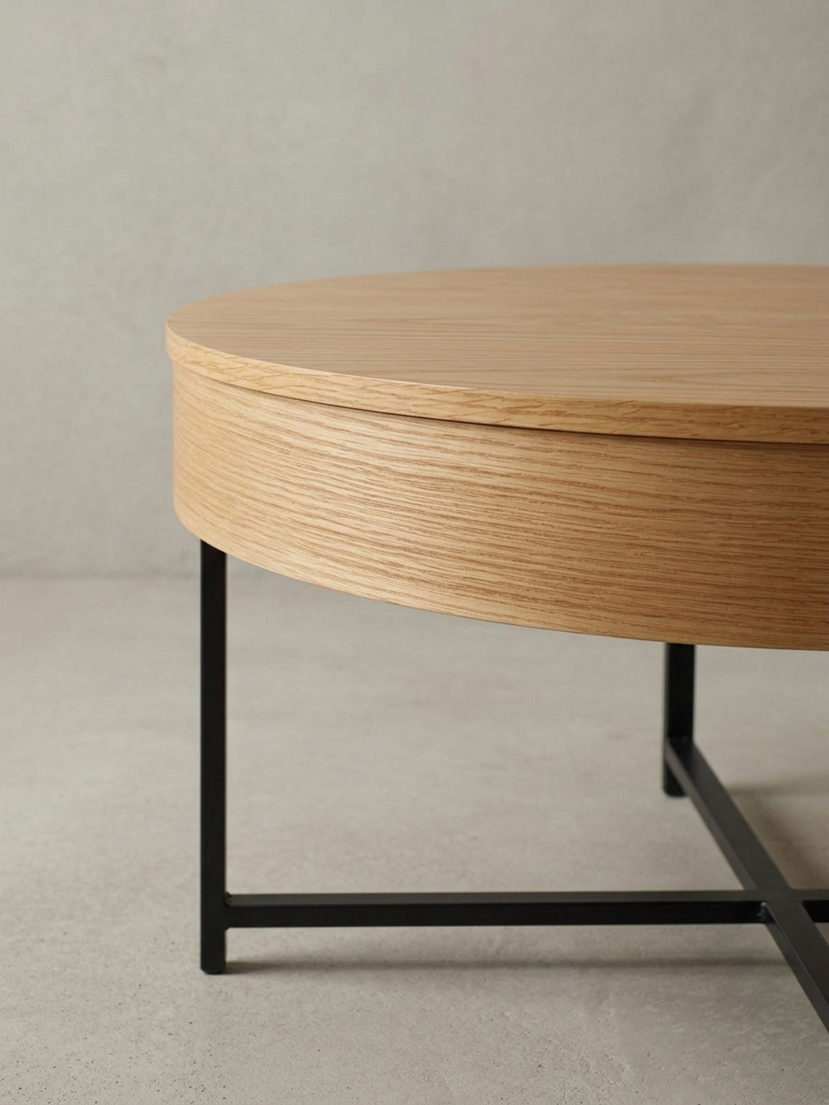 Detailaufnahme des Übergangs von der Eichenfurnier-Tischplatte zum mattschwarzen Stahlbein, die den Materialmix des modernen Lounge-Tisches betont.