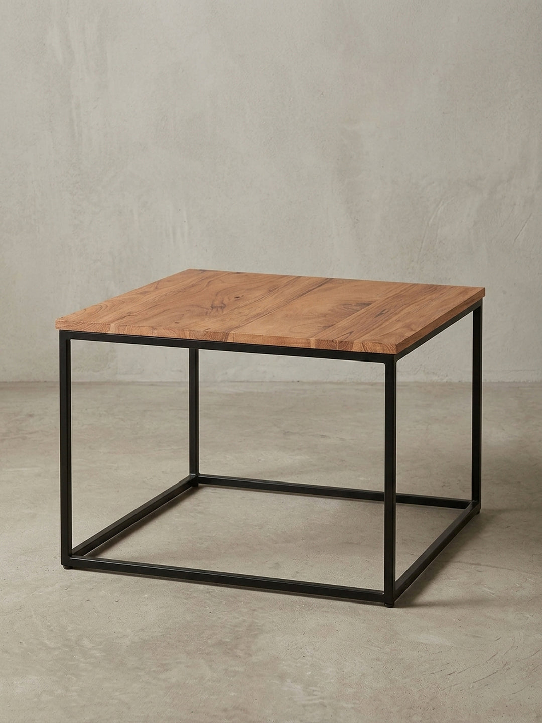 Kaffeetisch Industrial aus Holz und Metall in der 3/4-Ansicht, die die stabile Konstruktion des schwarzen Gestells und die Tiefe der Massivholzplatte hervorhebt._