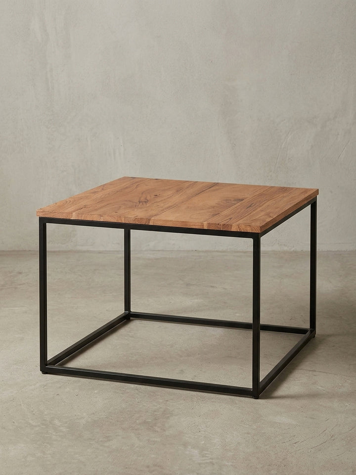 Kaffeetisch Industrial aus Holz und Metall in der 3/4-Ansicht, die die stabile Konstruktion des schwarzen Gestells und die Tiefe der Massivholzplatte hervorhebt._