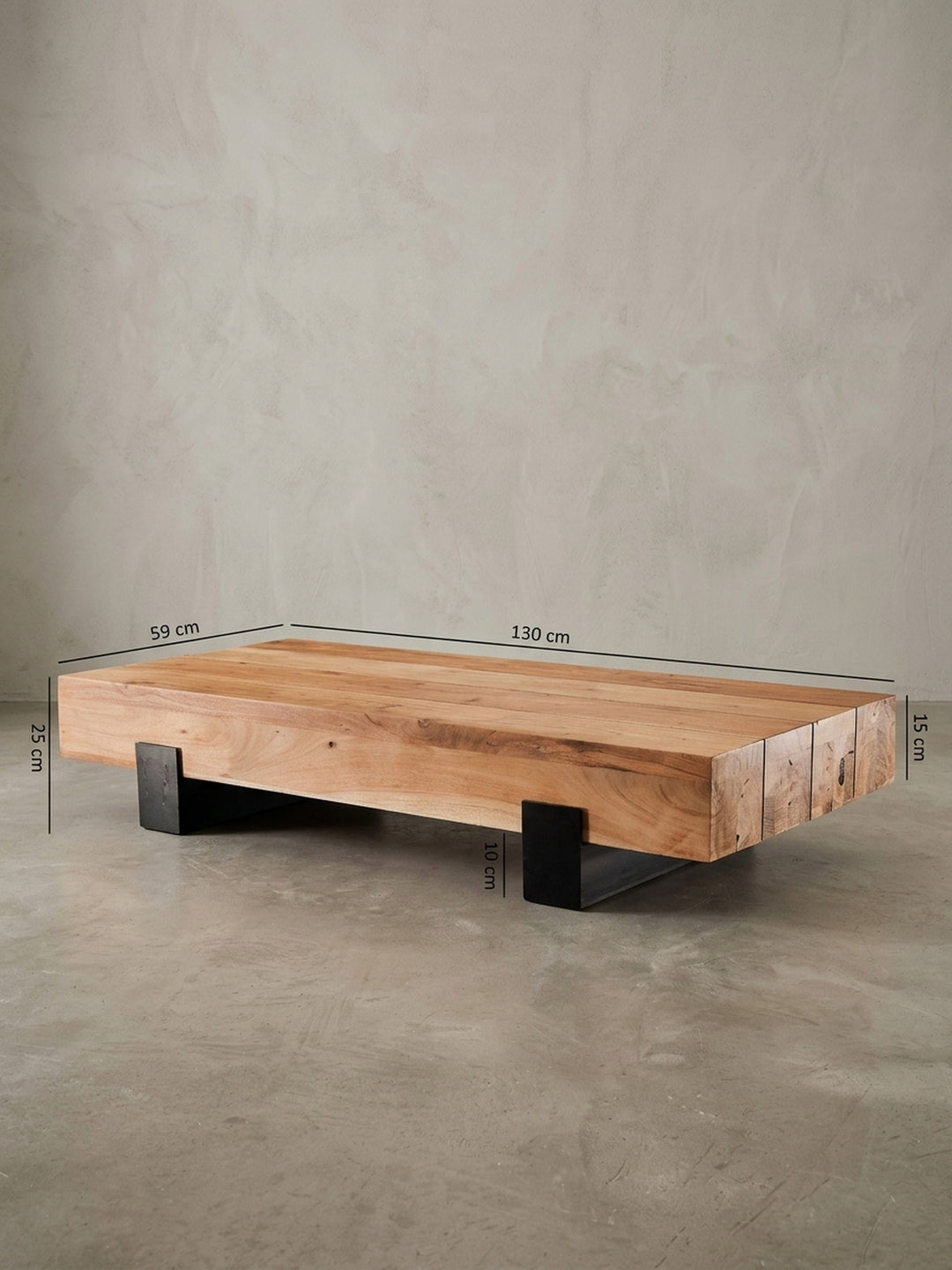 Detailansicht der Rückseite des Akazien-Couchtisches. Die unsichtbaren Verbindungen zwischen der schweren Massivholzplatte und dem soliden Metallgestell unterstreichen das cleane Design._