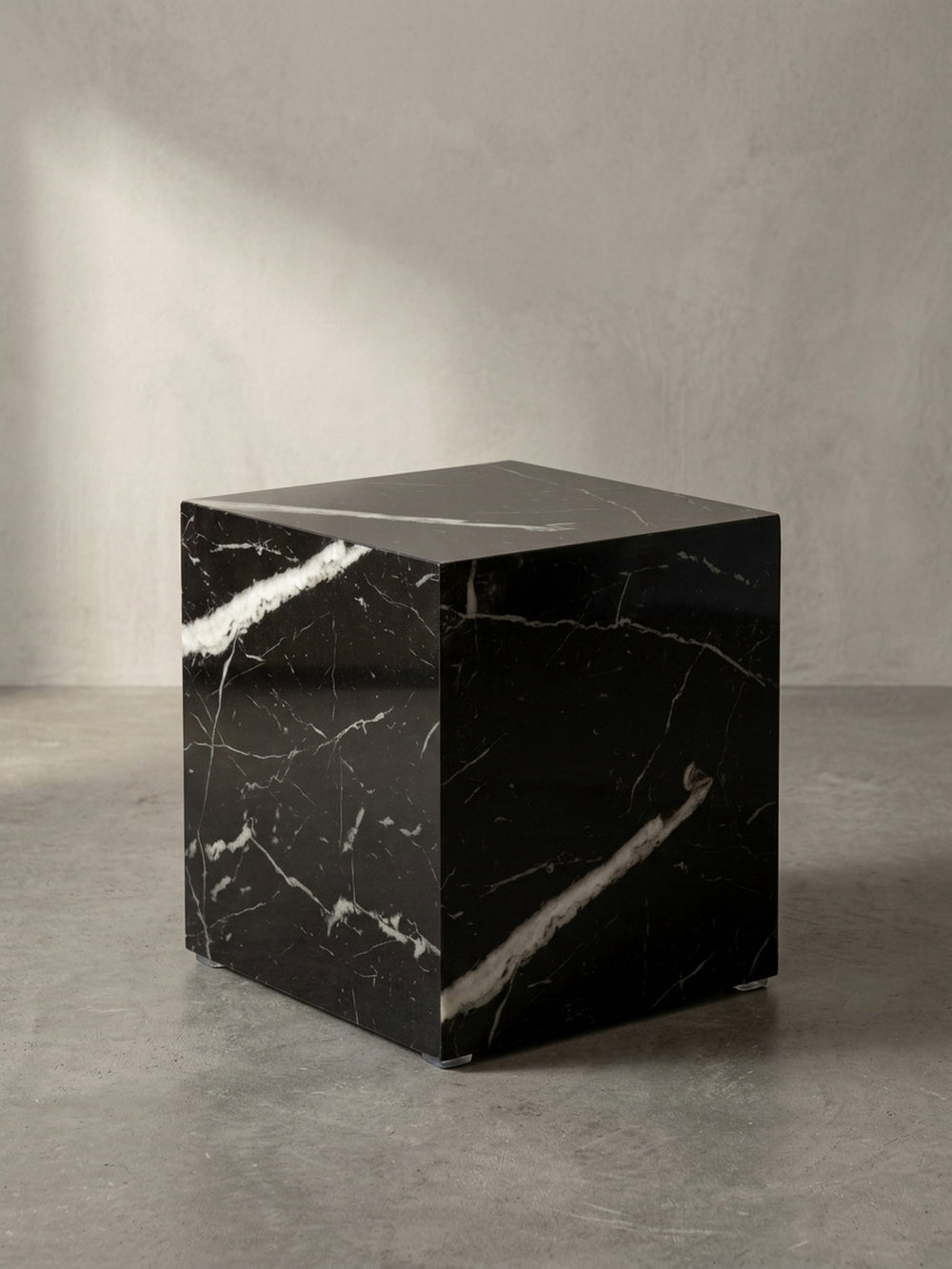 Quadratischer Sofatisch in Hochglanz-Schwarz aus der Dreiviertelperspektive, die die geometrische Form elegant betont._