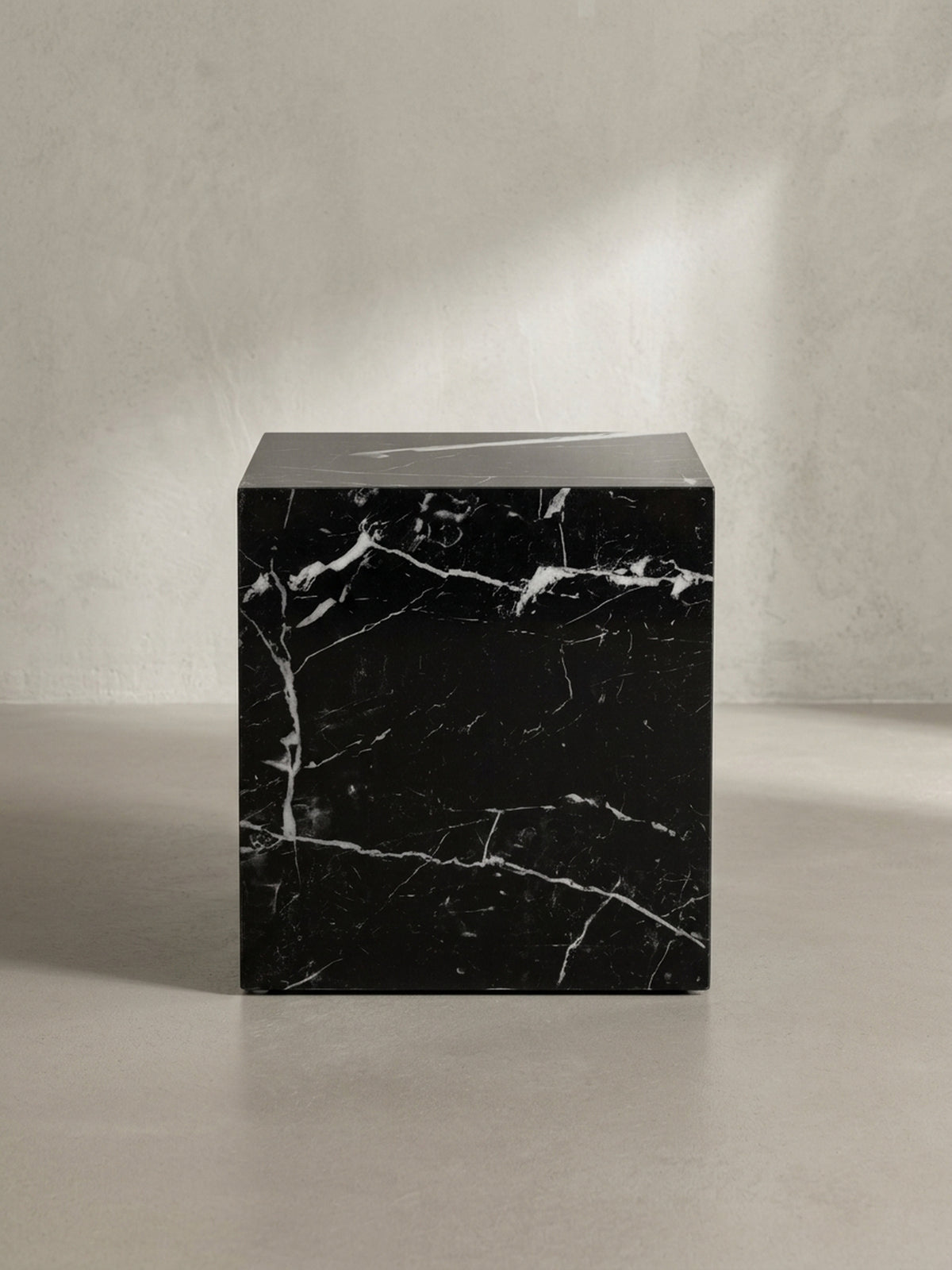 Seitenansicht des 45 cm hohen Beistelltischs, der seine schlanke und blockartige Silhouette in Marmoroptik präsentiert.