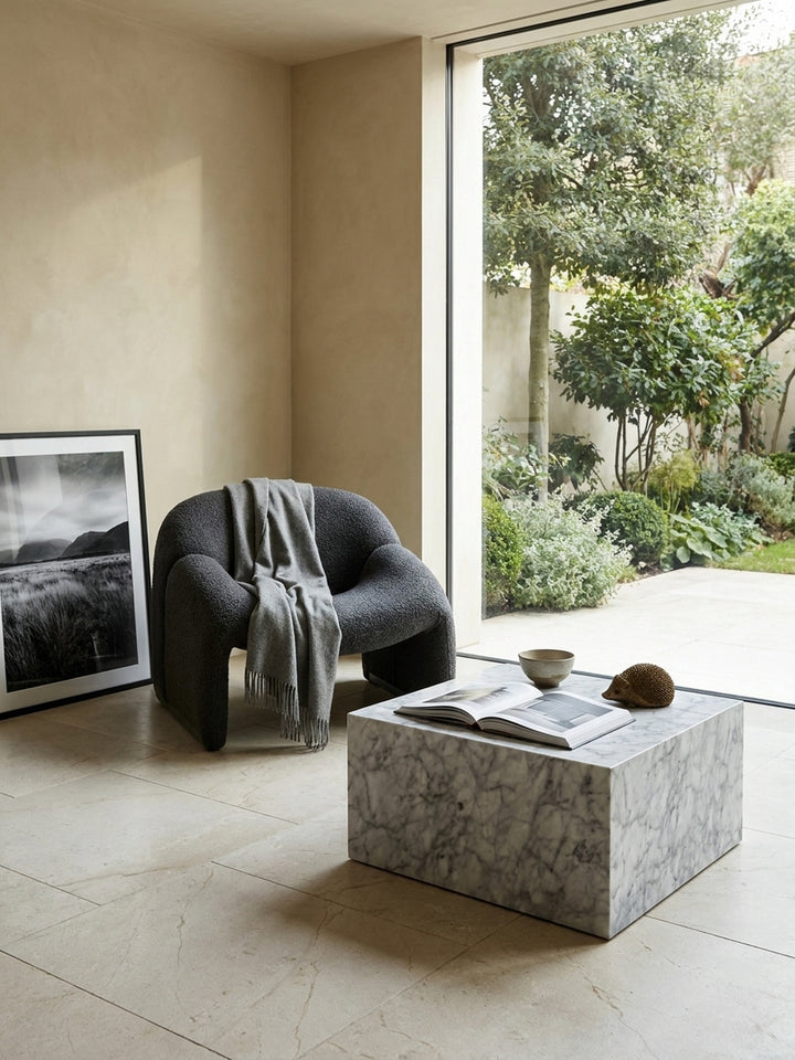 Monolithischer MDF-Couchtisch kombiniert mit minimalistischem anthrazitfarbenem Interieur und einem großformatigen abstrakten Kunstwerk in einer von kühler Eleganz geprägten zeitgenössischen Wohnumgebung._