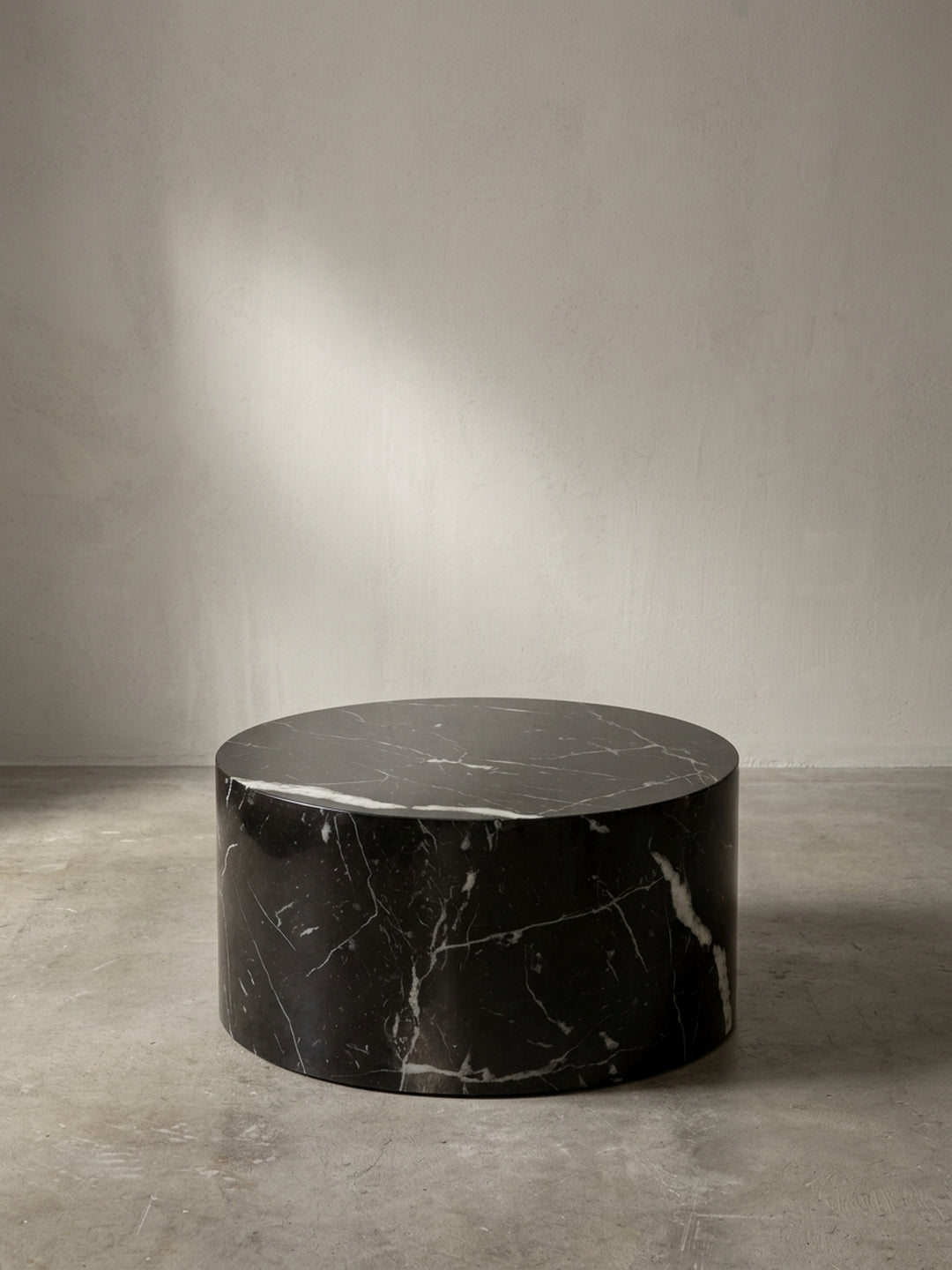 Seitenprofil des 30 cm hohen, runden Sofatischs, das seine niedrige und massive Statur auf weißem Hintergrund verdeutlicht._