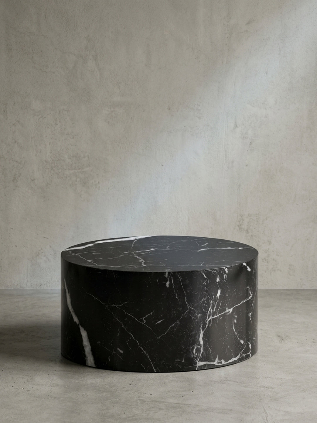 Gesamtansicht des modernen Couchtischs, der durch seine monolithische, runde Form und die ausdrucksstarke Marmor-Optik besticht._