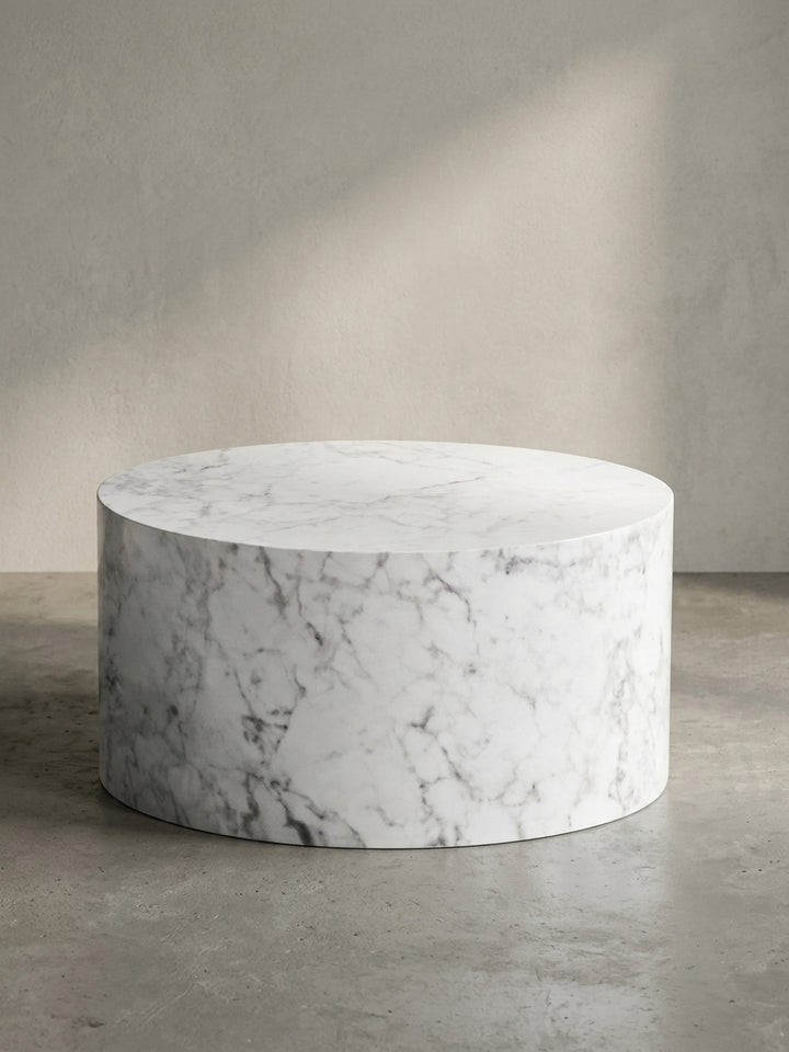 Leicht angewinkelte Seitenansicht des monolithischen runden Tisches, die seine solide zylindrische Form aus foliertem MDF hervorhebt._