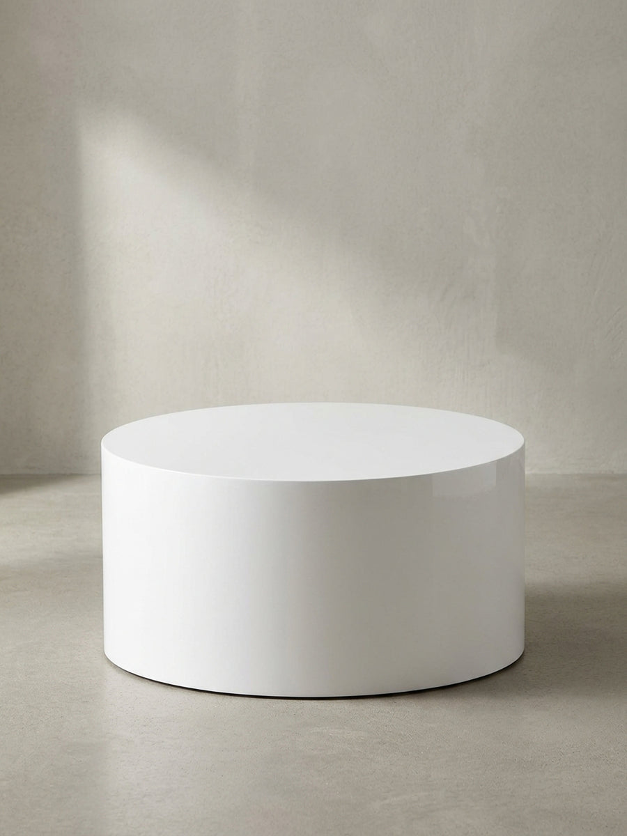Freigestellte Frontansicht des Couchtischs MONOBLOC in Weiß Hochglanz, der seine perfekte zylindrische und schlichte Form zeigt._